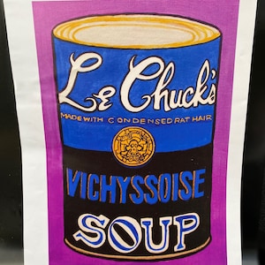 May include: A colorful illustration of a soup can labeled "Le Chuck's Vichyssoise Soup." The can is blue with white lettering and a gold rim. The text "Made with Condensed Rat Hair" is also visible.