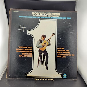 May include: Vintage vinyl record album cover for Sonny James, "The Southern Gentleman." The cover is black with a large white number one. It features a photo of Sonny James playing a guitar and song titles.