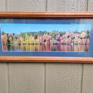 May include: Framed photograph of a lake scene with fall foliage reflected in the water. The caption reads "Basin Lake, 2003".