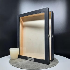 May include: Black wooden shadow box with a glass front and a silver metal plate with the text "The Morning Family" on it.