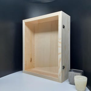 May include: A natural wood shadow box with a clear glass front and two metal hinges. The box is empty and ready to be filled with your favourite items.