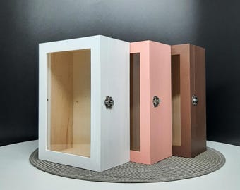 May include: Three wooden display boxes with clear glass fronts and metal latches. The boxes are white, pink, and brown.