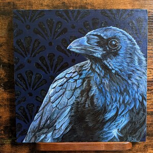 May include: A blue raven with a dark blue background featuring a repeating pattern of black fan shapes. The raven is looking to the left of the image. The artist's signature is in the bottom right corner.