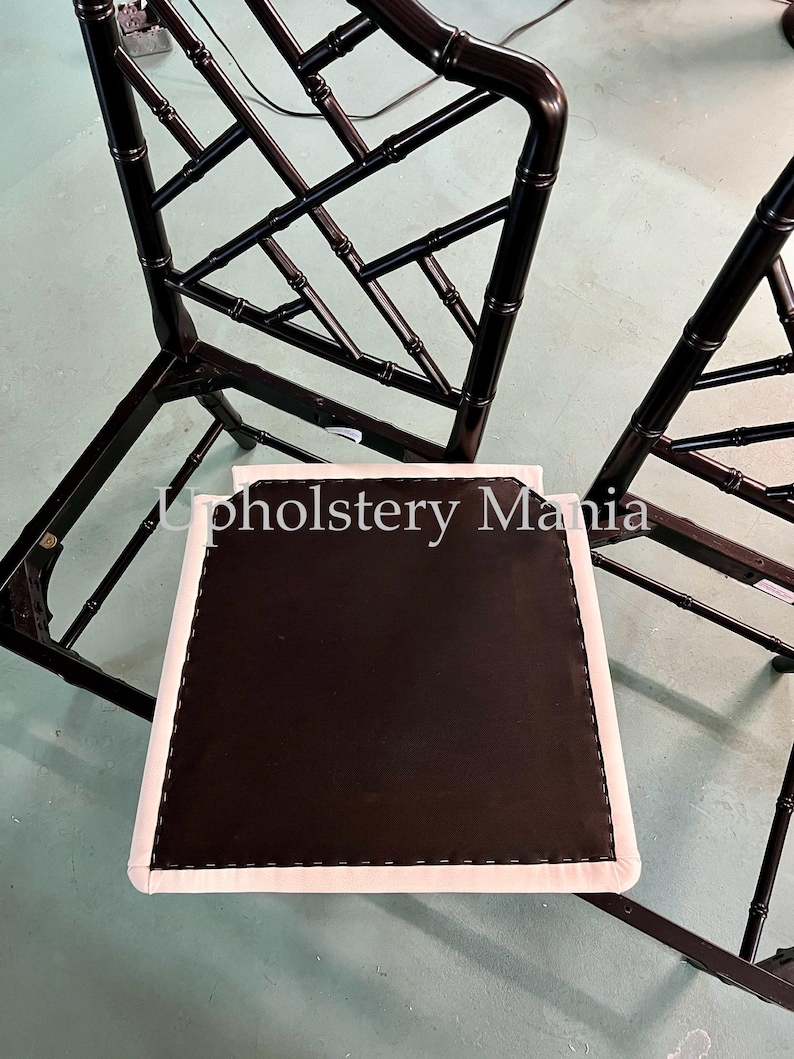 May include: Two black bamboo chairs with white cushions. The chairs have a diamond pattern and are in need of reupholstery.