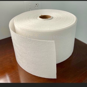 Puede incluir: Un rollo de tela no tejida blanca. La tela est&aacute; enrollada y tiene un n&uacute;cleo de cart&oacute;n. La tela se utiliza para tapicer&iacute;a y otras manualidades.