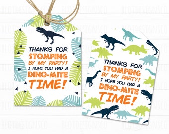 Könnte beinhalten: Zwei Dinosaurier-Geschenk-Etiketten mit weißem Hintergrund und grünen, blauen und schwarzen Dinosaurier-Illustrationen. Der Text auf den Etiketten lautet "Danke, dass du auf meiner Party rumgetrampelt hast! Ich hoffe, du hattest eine Dino-mäßige Zeit!"