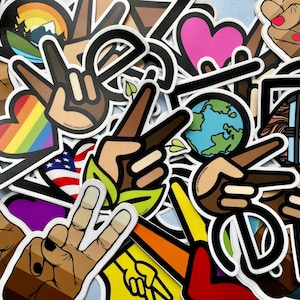 May include: A collection of colorful stickers featuring peace signs, hearts, and other symbols. The stickers are made of vinyl and have a glossy finish. They are perfect for decorating laptops, water bottles, and other surfaces.