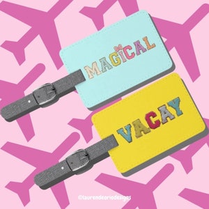 Op de afbeelding: Twee bagagelabeltjes met kleurrijk geborduurd tekst. Het blauwe labeltje zegt "MAGICAL" en het gele labeltje zegt "VACAY".