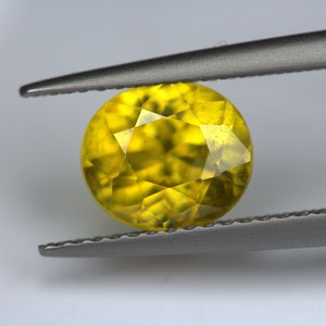 2.11 Karat Sphene Oval 8,85 x 6,85 mm . Facettierteoval. Erstaunliches Feuer mit glühender Farbe.