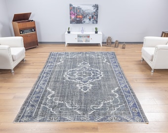 May include: A vintage-style rug with a faded blue and white pattern. The rug has a distressed look and features a central medallion design.