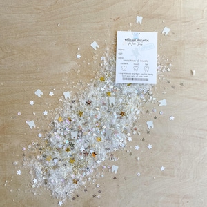 May include: An "Official Receipt" for a tooth, with space for name, age, and date, rests on a wooden surface. White, gold, and silver star and tooth-shaped confetti surround the receipt. The receipt has a stamp that says "Approved".