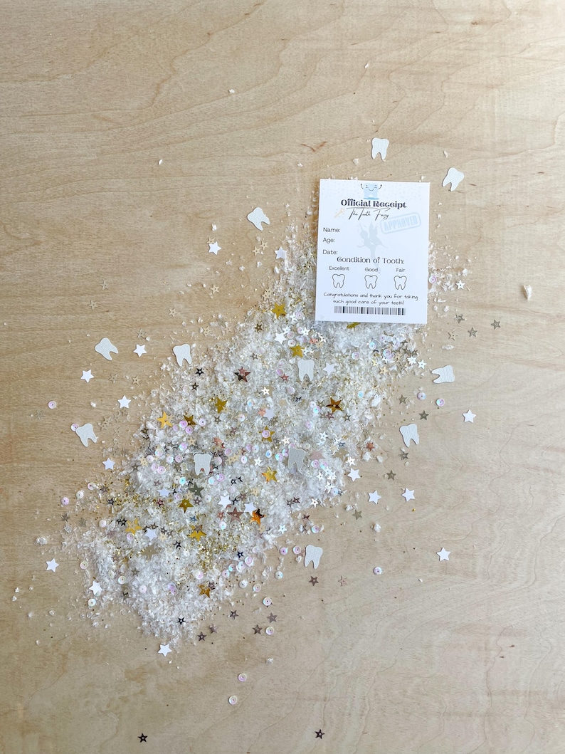 May include: An "Official Receipt" for a tooth, with space for name, age, and date, rests on a wooden surface. White, gold, and silver star and tooth-shaped confetti surround the receipt. The receipt has a stamp that says "Approved".