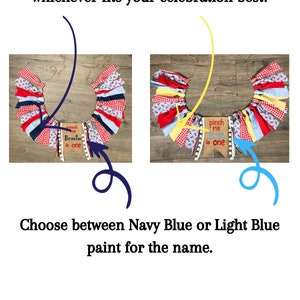 May include: Two images showing a red, white, and blue fabric banner with the text "Pinch Me Braxton is One". The banner is decorated with white pom-poms. The first image shows the banner with a navy blue fabric background. The second image shows the banner with a yellow fabric background.