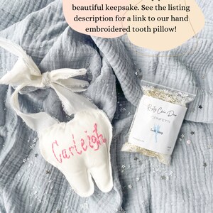 May include: A handmade white tooth fairy pillow with the name "Carleigh" embroidered in pink. A small bag of confetti and text that reads "Rasty Chic Duo Confetti Tooth Fairy" are also in the image.