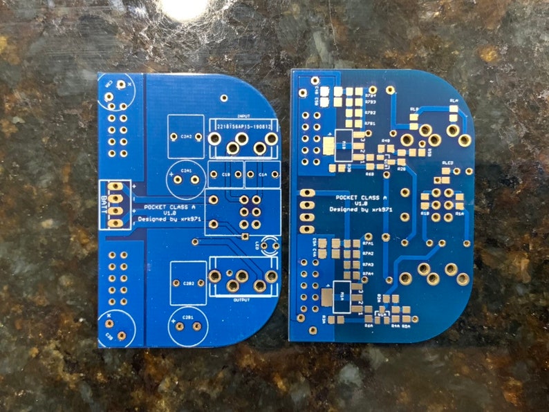 May include: Two blue circuit boards with gold-colored components and text. The left board has the text "POCKET CLASS A U1.8 Designed by wr371". The right board has the text "POCKET CLASS ULB Designed by wr371".
