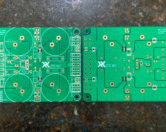 May include: Two green circuit boards with gold-colored traces and components. The board on the left has three circular areas with components inside. Both boards have the text "JPA4  Stereo  Hi-Fi  PSU" printed on them.