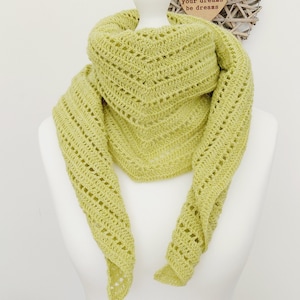 May include: A lime green crocheted scarf with a delicate openwork pattern. The scarf is draped over a white mannequin. The text "Don't let your dreams be dreams" is written on a wooden heart.