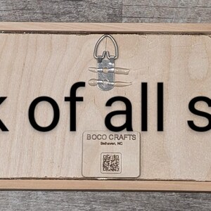 This is the back of all the signs. All natural wood with a hanger in the center and our tag with our name, BOCO CRAFT, where we live, Belhaven, NC and a QR code to our Facebook page.