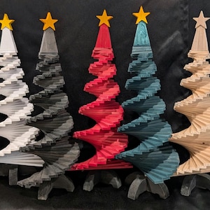 May include: Five wooden Christmas trees in white, gray, red, teal, and natural wood tones. Each tree has a spiral design and is topped with a yellow star. The trees are displayed on a dark background.