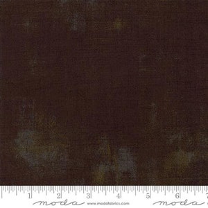 May include: A dark brown fabric with a subtle textured pattern and a slightly faded look. The fabric has a subtle sheen and a soft, smooth feel.