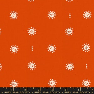 May include: Orange fabric with a repeating pattern of white suns with smiling faces and triangular rays. The fabric also features small white arrow-like shapes. The words "RUBY STAR SOCIETY" are printed at the bottom.