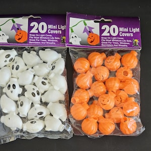 May include: Two packs of 20 Halloween mini light covers. One pack contains white ghost-shaped covers and the other contains orange pumpkin-shaped covers. The packs have the text "20 Mini Light Covers" and instructions for use.