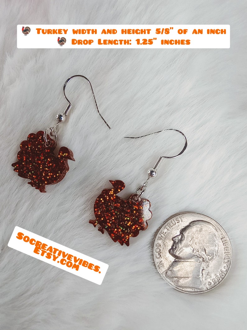 May include: A pair of dangle earrings featuring a glittery orange turkey silhouette. The earrings are 5/8 inch wide and tall, with a drop length of 1.25 inches. "TURKEY WIDTH AND HEIGHT 5/8" OF AN INCH DROP LENGTH: 1.25" INCHES" is written in orange text at the top of the image. "SOCREATIVEVIBES. ETSY.COM" is written in orange text at the bottom of the image.
