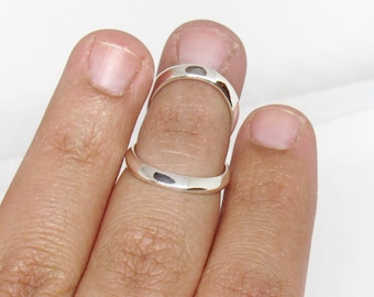 May include: Two silver rings worn on a finger. The rings are simple and plain, with a smooth, polished finish.
