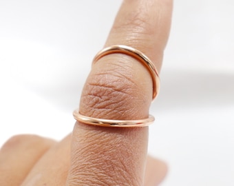 May include: Two thin gold rings worn on a finger.