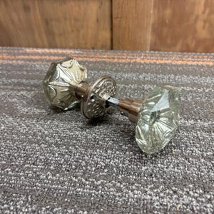 Juego de pomos de puerta extragrandes de cristal tallado con placas decorativas redondas.