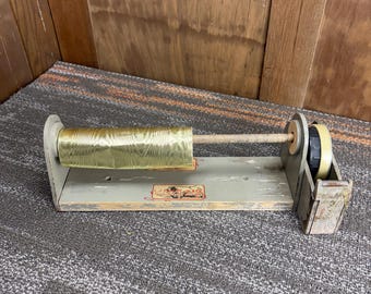 Expositor de madera antiguo para papel de regalo y cinta adhesiva de una tienda general.