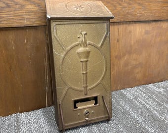 Buzón de pared antiguo de metal con la antorcha de la victoria de la Libertad de 1918, Primera Guerra Mundial, Fulton, Illinois, EE. UU.