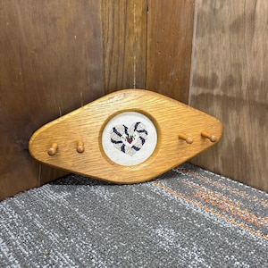 May include: A handmade wooden sign with the text "Welcome" in a handwritten style. The sign is painted white with a distressed finish, and a small, decorative heart is attached. The sign measures approximately 12 inches wide.