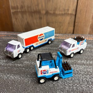 May include: A set of three ceramic mugs with a speckled, matte finish. The mugs are in shades of cream, light gray, and dark gray. Each mug has a simple, minimalist design and a rounded handle. Perfect for coffee or tea.