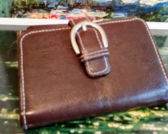 Small brown wallet with buckle decoration, snap closure