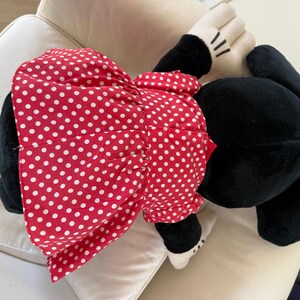 Authentic vintage Disney Parks Minnie Mouse plush with her recognizable red bow and classic dress. A perfect collectible for fans of 90s Disney nostalgia.