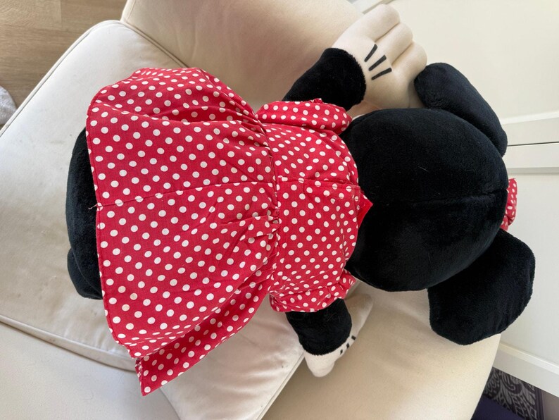 Authentic vintage Disney Parks Minnie Mouse plush with her recognizable red bow and classic dress. A perfect collectible for fans of 90s Disney nostalgia.