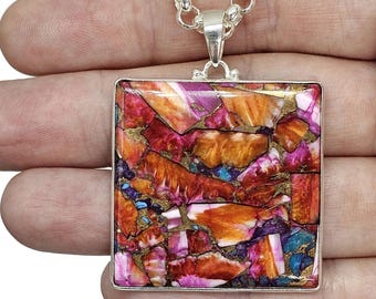 Könnte beinhalten: Eine silberne Kettenkette mit einem quadratischen Anhänger mit einem farbenfrohen, abstrakten Muster aus Rot, Orange, Pink und Gold. Der Anhänger ist aus einem Naturstein mit einer einzigartigen, marmorierten Optik.