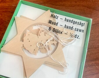 May include: A package of six wooden star ornaments, hand-sawn and ready to be decorated. The package is labeled "Holz - handgesägt Wood - hand-sawn 6 Stück - 1/2 dz."