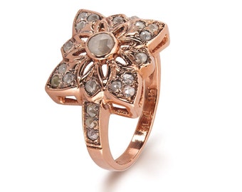 Può includere: Un anello in oro rosa con un design a forma di fiore incastonato con diamanti. L'anello è contrassegnato "14K" sulla fascia interna.
