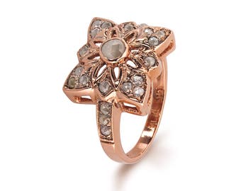 Può includere: Un anello in oro rosa con un design a forma di fiore incastonato con diamanti trasparenti. L'anello è contrassegnato da "14K 750".