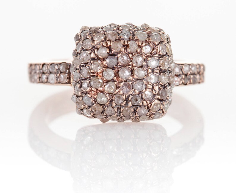 Peut inclure: Une bague en or rose avec une pierre centrale de forme carr&eacute;e sertie de petits diamants blancs. La bande est &eacute;galement sertie de petits diamants.