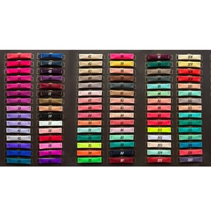 May include: A color chart with 150 small fabric swatches, each labeled with a number from 1 to 150. The swatches are arranged in rows and columns, and the colors range from white to black.