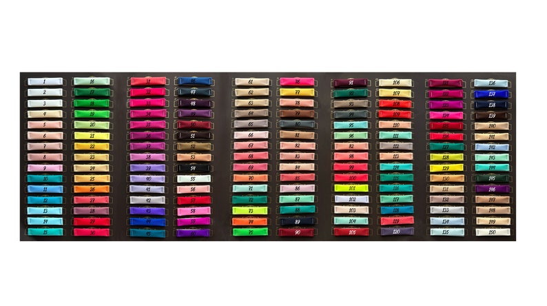 May include: A color chart with 150 small fabric swatches, each labeled with a number from 1 to 150. The swatches are arranged in rows and columns, and the colors range from white to black.
