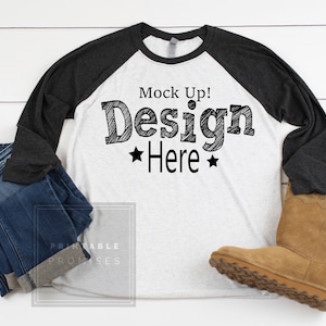 May include: A white and black baseball tee shirt with a black and gray raglan sleeve. The shirt has the text "Mock Up! Design Here" printed on the front.