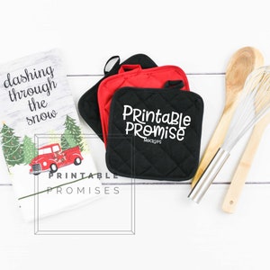 May include: A white kitchen towel with a red truck and Christmas trees, the text "dashing through the snow" and the words "Printable Promises".  Two black and red quilted pot holders with the text "Printable Promise Mockups". A wooden spoon and a silver whisk.