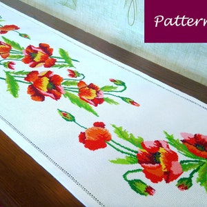 May include: White table runner with a red, yellow, and green embroidered poppy flower design. The pattern is called "Pattern".