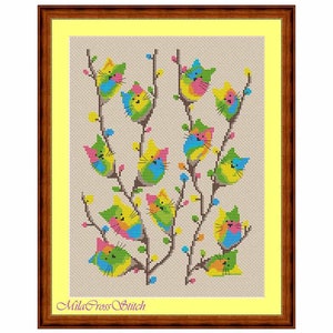 May include: Cross stitch pattern featuring a whimsical design of colorful cats perched on branches of a tree. The cats are depicted in various poses, with their tails curled around the branches. The background is a light beige fabric.