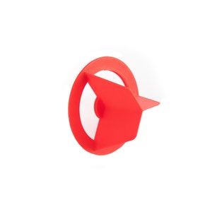 May include: A red plastic arrow with a circular base. The arrow is pointing to the right.