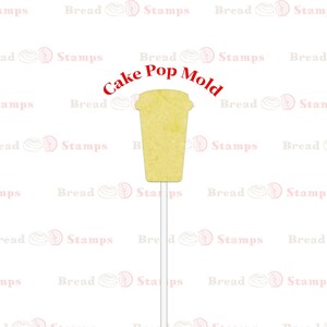 May include: A yellow cake pop mold shaped like a coffee cup. The mold is on a white stick and has a textured surface. The text "Cake Pop Mold" is written in red above the mold.